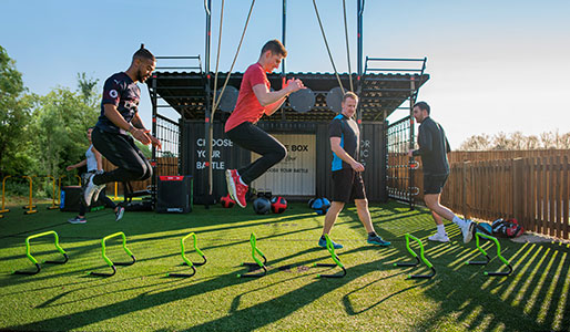 Image of a group of people jumping over small hurdles during a Battlebox class